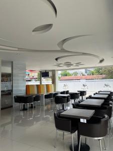 a dining room with black tables and chairs at Melati Hotel in Tanjungredep