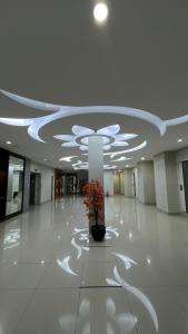 a lobby with a potted plant in the middle of a building at Melati Hotel in Tanjungredep