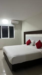 a bedroom with a large white bed with red pillows at Melati Hotel in Tanjungredep +10 photos