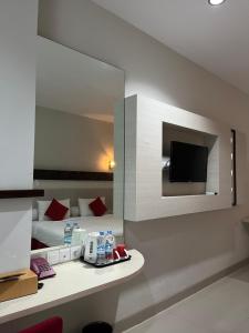 a hotel room with a bed and a mirror at Melati Hotel in Tanjungredep