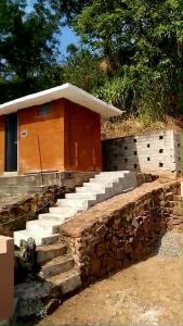 a building with a set of stone steps next to a house at Glamping by CampingLyfe in Bandarawela