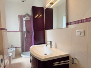 a bathroom with a sink and a mirror and a toilet at Corso79 in Porto Santo Stefano