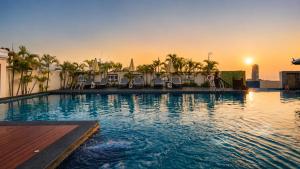 a swimming pool with chairs and umbrellas on a building at Aiyara Palace in North Pattaya +65 photos