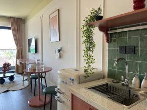 a kitchen with a sink and a table in a room at Homestay- Phòng nghỉ Lazur Cửa Lò in Giáp Vinh Yên