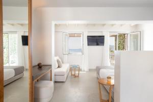 a living room with white furniture and windows at Santana Beach in Agia Anna Naxos