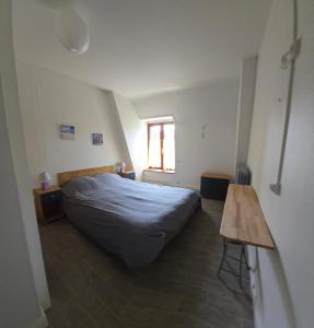 a bedroom with a bed and a wooden table at Le Relais d'Heugnes in Heugnes