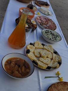 a table with plates of food and a bottle of sauce at Raj pod Košenjakom in Dravograd +8 photos