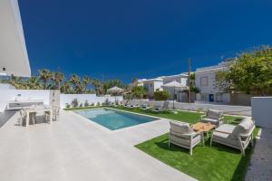 a patio with a pool and chairs and a table at Ocean Whispers Villas in Paralimni