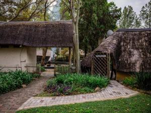 a house with a thatch roof and a brick walkway at Pinewood Cottages in Renos +17 photos