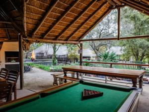 a pool table in front of a pavilion with a pool table at Pinewood Cottages in Renos