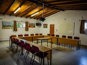 a conference room with tables and chairs and a whiteboard at Pinewood Cottages in Renos