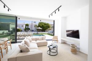 a living room with a white couch and a table at Ocean Whispers Villas in Paralimni