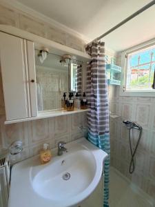 a bathroom with a sink and a shower curtain at Molyvos Sunset Horizon in Mythimna +15 photos