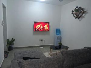 a living room with a couch and a tv on a wall at PAZURI - Homes2 in Voi +12 photos