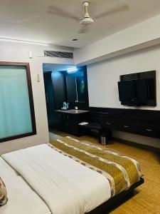 a bedroom with a bed and a flat screen tv at Hotel Cymbal -Sector 31 Gurgaon in Gurgaon