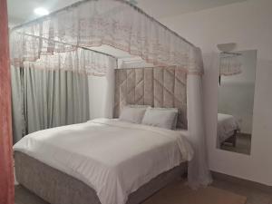 a bedroom with a large bed with a canopy at PAZURI - Homes2 in Voi