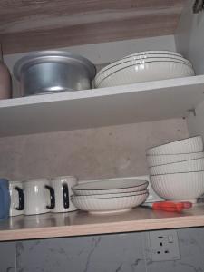 a shelf with bowls and other dishes on it at PAZURI - Homes2 in Voi