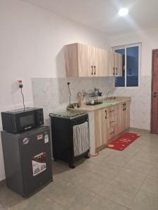 a kitchen with a microwave and a refrigerator at PAZURI - Homes2 in Voi