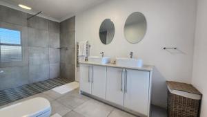 a bathroom with two sinks and a shower at Apollo on Sea in Velddrif +12 photos