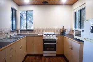 a kitchen with a stove and a sink at #2 Walpole Wilderness Resort chalet. Spa + forest. in Walpole