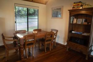 a dining room with a table and chairs and a window at #2 Walpole Wilderness Resort chalet. Spa + forest. in Walpole +27 photos