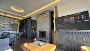 a living room with a fireplace and a flat screen tv at NEVO FAQRA Elevate Your Stay! in Ḩaqlat as Sayyid