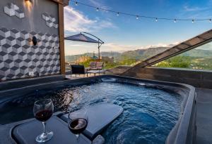 a hot tub with two glasses of wine in it at NEVO FAQRA Elevate Your Stay! in Ḩaqlat as Sayyid