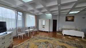 a living room with white furniture and a tv at Caprice Monteoru in Sărata-Monteoru