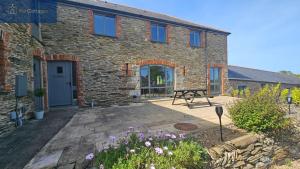 a stone house with a patio in front of it at Karadow in Saint Just in Roseland