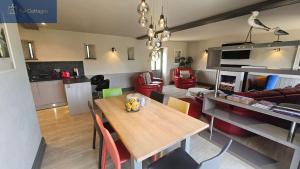 a kitchen and living room with a wooden table at Karadow in Saint Just in Roseland