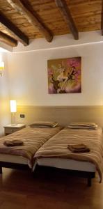 a bed in a bedroom with a painting on the wall at La casa delle fate in Lusevera