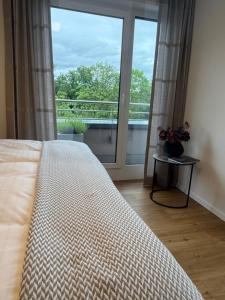 a bedroom with a bed and a large window at Premium Penthouse Parkblick in Bad Driburg +25 photos