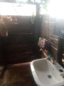 a bathroom with a white sink and a television at Weaver's Nest Backpackers Accommodation in Nyanda