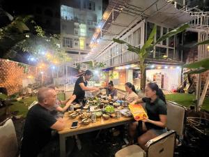 a group of people sitting at a table eating food at Nice Hotel Buôn Ma Thuột in Buon Ma Thuot
