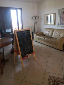 a chalk board in a living room with a couch at Domo Mea in Orgosolo