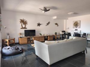 a living room with a white couch and a tv at Marfolin 5 in El Cotillo