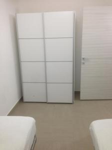 オリスターノにあるCasa Fenughedduの白いクローゼット2つとドアが備わる部屋