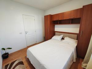 a bedroom with a white bed and wooden cabinets at Virajlux Verde Retreat in Mioveni +14 photos
