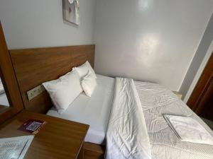 a small bedroom with a bed and a table at KIGALI FANTASTIC Aparthotel in Kigali +2 photos