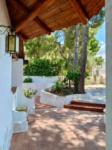 a patio with a tree and a wooden roof at Villa Calipso in Taranto