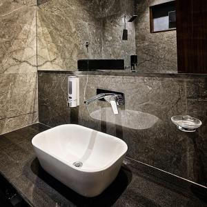a bathroom with a white sink on a counter at Hotel Aroma in Mathura +23 photos