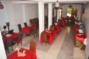 a restaurant with red tables and chairs in a room at Arenah hotel in Yaoundé +3 photos