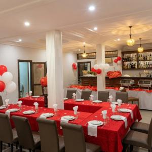 a banquet hall with red and white tables and chairs at Arenah hotel in Yaoundé