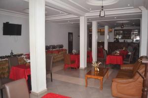 a dining room with red tables and chairs at Arenah hotel in Yaoundé