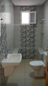 a bathroom with a sink and a toilet and a window at Dar Frdj in Sousse