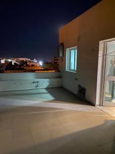 an empty room with a view of a city at night at Dar Frdj in Sousse