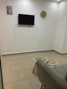 a living room with a couch and a tv on a wall at Dar Frdj in Sousse +2 photos