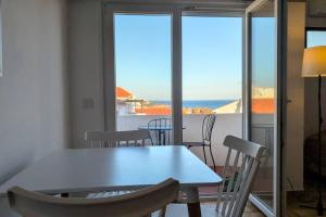 a white table and chairs with a view of the ocean at 1D Albufeiras Baysight flat in Albufeira