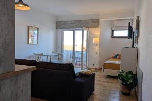 a living room with a couch and a bedroom at 1D Albufeiras Baysight flat in Albufeira