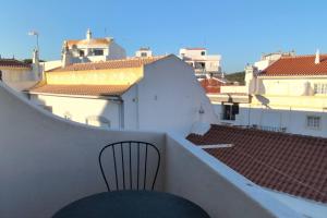 a black chair sitting on a balcony with buildings at 1D Albufeiras Baysight flat in Albufeira